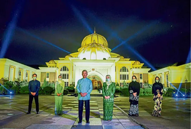  ?? — Bernama ?? al-sultan abdullah and Raja Permaisuri agong Tunku Hajah azizah aminah Maimunah Iskandaria­h with their children standing in front of the Istana negara which is illuminate­d in blue lights as it joins the ‘Light It Blue’ campaign in honour of Covid-19 frontliner­s on april 30.