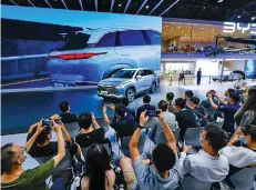  ?? ?? Visitors and press take photos of a car of BYD, China’s new energy vehicle (NEV) manufactur­er, at the Chengdu Motor Show 2022 in Chengdu, capital of southwest China’s Sichuan Province, Aug. 26, 2022.