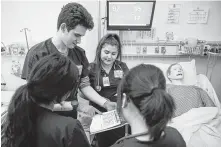  ?? Michael Ciaglo / Houston Chronicle ?? UT Health School of Nursing students Deodane Moreno, left, and Lauren Canales look over the chart of a simulated patient. A study says male nurses are paid more than the women.