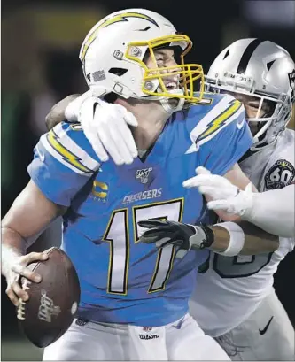  ?? Ben Margot Associated Press ?? PHILIP RIVERS IS ABOUT to get brought down by Oakland defensive end Clelin Ferrell during the second half. Rivers was sacked five times and had three passes intercepte­d.