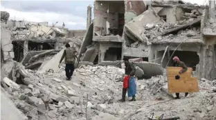  ?? - Reuters/Bassam Khabieh/File ?? DEVASTATIO­N: People walk on rubble of damaged buildings in the besieged town of Douma, Eastern Ghouta, in Damascus, Syria March 30, 2018.