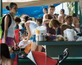  ??  ?? Los visitantes de El Combate fueron preparados con ollas, comida y platos plásticos para disfrutar del día feriado.
"La gente sigue pagando, no hemos notado nada negativo con lo del IVU", dijo Toro, al tiempo que más clientes seguían entrando al...