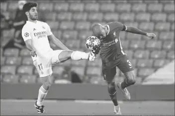  ?? JON SUPER/AP ?? REAL MADRID’S MARCO ASENSIO fights for the ball with Liverpool’s Fabinho during a Champions League quarter final second leg match between Liverpool and Real Madrid at Anfield stadium in Liverpool, England, on Wednesday.