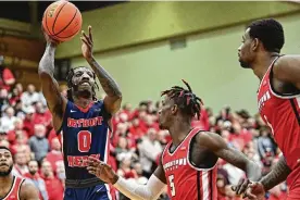  ?? DAVID DERMER / AP ?? Detroit Mercy guard Antoine Davis shoots over Youngstown State guard Dwayne Cohill during the first half of a Horizon League tournament game Thursday in Youngstown, Davis scored 22 points to end his college career four points shy of setting college basketball’s all-time scoring record.