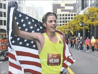  ?? Nate Guidry/Post-Gazette ?? Martin Hehir holds the American flag after finishing in first place Sunday for the men’s division of the EQT Pittsburgh 10 Miler race.