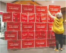  ?? TONY CALDWELL ?? Nathalie Montpetit assembles signs for Orleans Liberal candidate MarieFranc­e Lalonde before the polls close Monday.