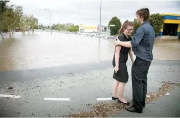  ??  ?? Des travailleu­rs patrouille­nt un quartier de Beenleigh, inondé par le passage du cyclone Debbie. Sur la photo du bas, on voit une femme en pleurs après avoir découvert son véhicule submergé par la montée des eaux en Australie.