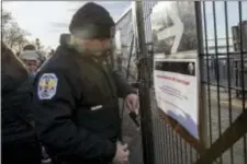  ?? MARY ALTAFFER - THE ASSOCIATED PRESS ?? A United States Park Police officer post a sign informing of the Statue of Liberty and Ellis Island closing at an entrance to the ferry, Saturday in New York. The National Park Service announced that the Statue of Liberty and Ellis Island would be...