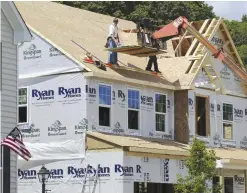  ?? —AP ?? Builders work on the roof of a home under constructi­on at a housing plan in Jackson Township, Butler County, Pa. The Commerce Department reported on US home constructi­on in June.