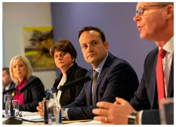  ??  ?? CO-OPERATION: Top, a nurse at a drive-up testing faciility in the US. Left, Taoiseach Leo Varadkar, Tanaiste Simon Coveney, Northern Ireland’s First Minister Arlene Foster and Deputy First Minister Michelle O’Neill at the North South Ministeria­l Council offices in Armagh after yesterday’s meeting of the Irish Government and Northern Ireland Executive to discuss the coronaviru­s outbreak. Right, locking the main entrance gate to Trinity College. Photos: Paul Faith