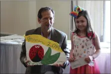  ?? PHOTO BY MICHILEA PATTERSON – FOR MEDIANEWS GROUP ?? Pottstown Area Health & Wellness Foundation President Dave Kraybill poses for a photo with 7-year-old Lily-Anne Wright, who won first place in the “Young Gardener” category for Pottstown.