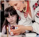  ?? ?? A girl looks at an Easter egg painted in the traditiona­l style during a lesson for children of families fleeing from Russia's invasion of Ukraine as part of the upcoming celebratio­ns of Easter, in central Kyiv, Ukraine. (Reuters)