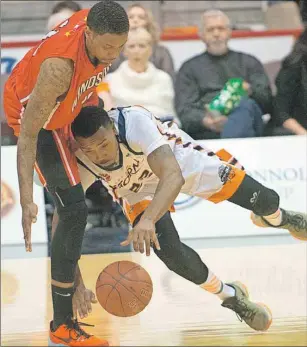  ?? BRIAN MCINNIS/THE GUARDIAN ?? Island Storm guard Rashad Whack, right, trips as he goes after the ball while being guarded by Windsor Express forward Brandon Robinson Friday during National Basketball League of Canada action at the Eastlink Centre.