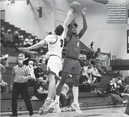  ?? ALLEN CUNNINGHAM/SUN-TIMES ?? West Aurora’s Josh Pickett lines up a three-pointer under pressure from Lockport’s Alex Vassilakis in the opener of the Pontiac Holiday Tournament on Tuesday.