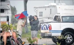  ?? AP PHOTO ?? A Bolivar Peninsula resident holds his umbrella while being interviewe­d as hurricane Harvey approaches the Texas coast Friday, Aug. 25.