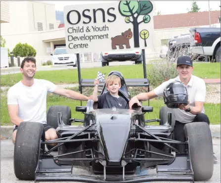  ?? MARK BRETT/Local Journalism Initiative ?? Charlie Moore, 5, of the OSNS Child and Youth Developmen­t Centre is in the driver's seat of this souped up racer owned by Adrian Neill (left) a member of the Area 27 Motorsport­s Park. With them is Mark Melissen, president of Wildstone Constructi­on Group.