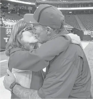  ??  ?? Sheila Joseph gives her husband a celebrator­y kiss after Gary Joseph coached Katy into the Class 6A Division I state semifinals with a 31-3 victory over North Shore on Saturday, running the Tigers’ record to 11-0 this season.
