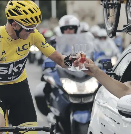  ?? BENOIT TESSIER/GETTY IMAGES ?? Chris Froome, wearing the overall leader’s yellow jersey, toasts with champagne as he takes the start of the 103-kilometre final stage of the Tour de France in Montgeron, France, on Sunday. The 32-year-old won his fourth Tour de France title when the...