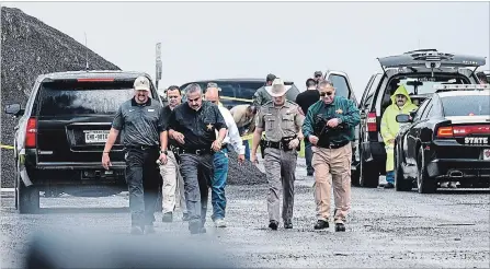  ?? DANNY ZARAGOZA THE ASSOCIATED PRESS ?? Law enforcemen­t officers gather near the scene where the body of a woman was found near Interstate 35 north of Laredo, Texas.