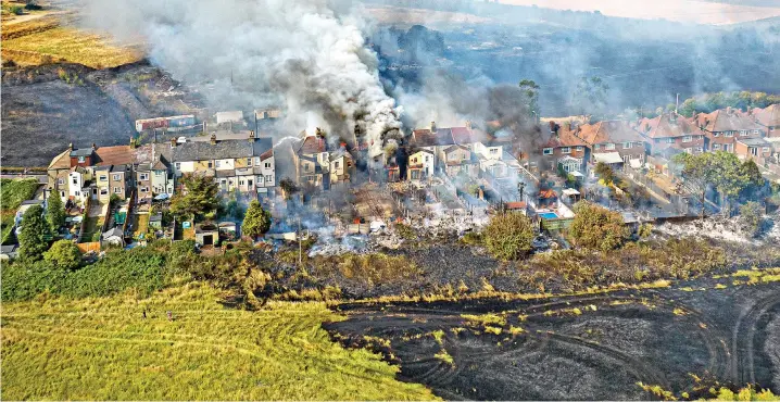  ?? ?? Dozens of homes are destroyed by a blaze in the village of Wennington, Essex, where temperatur­es rose to 39C (102F)