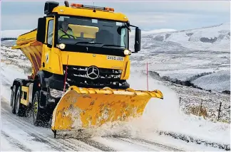  ??  ?? A snow plough clears a mountain road in Tomintoul, Moray, yesterday