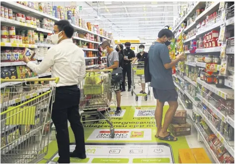  ?? ?? Customers examine food items at a Big C supermarke­t in Bangkok. Mr Wichanun says the inflation rate is trending downwards. Nutthawat wicheaNbut