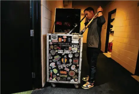  ?? Photos by Scott Strazzante/The Chronicle ?? Giants clubhouse assistant Austin Ginn rearranges items in the bat trunk before Wednesday’s home game against the Rockies.