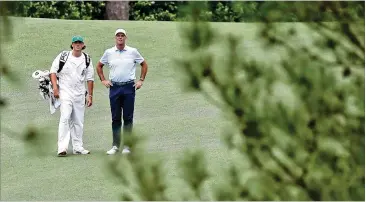  ?? CURTIS COMPTON/CURTIS.COMPTON@AJC.COM ?? Caddie Reagan Cink and his father, Stewart Cink, prepare to hit on the second fairway in Saturday’s third round of the Masters at Augusta National. After an even-par round, he remains at 1 under.
