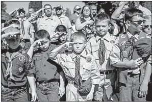  ?? AP/The Flint Journal-MLive.com/JAKE MAY ?? Boy Scouts and Cub Scouts salute during a Memorial Day ceremony on May 29 in Linden, Mich. On Wednesday, the Boy Scouts of America Board of Directors unanimousl­y approved to welcome girls into its Cub Scout program.