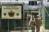  ?? BRENNAN LINSLEY — THE ASSOCIATED PRESS FILE ?? On June 27, 2006, U.S. military guards walk within the Camp Delta military-run prison at the Guantanamo Bay U.S. Naval Base in Cuba.