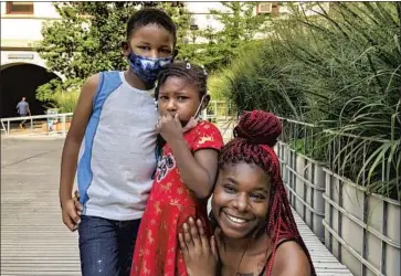  ?? Noah Bierman Los Angeles Times ?? ERICA WILKINS, 30, with children Kabir Grant, 6, and Neveah Grant, 4, outside Philadelph­ia City Hall. “I don’t hear that much about her,” Wilkins said of Kamala Harris. “I will say I am proud of her as a woman.”