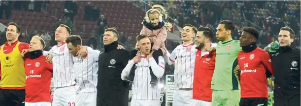  ?? FOTO: JANNING ?? Düsseldorf­er Feierlichk­eiten vor der Südtribüne nach dem 4:2 gegen Bielefeld. Rouwen Hennings’ Tochter trägt zur Sicherheit Ohrenschüt­zer – nicht wegen der Kälte, sondern wegen der Lautstärke.