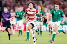  ??  ?? Kenki Fukuoka, center, runs past Ireland’s defense during Saturday’s game.