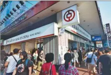  ?? RICO WONG / FOR CHINA DAILY ?? Pedestrian­s walk past a branch of Bank of China in Hong Kong.