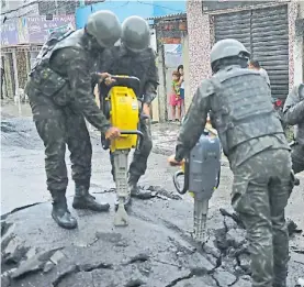  ?? AFP ?? Acción. Desarme de una barrera narco en una calle en Vila Kennedy.