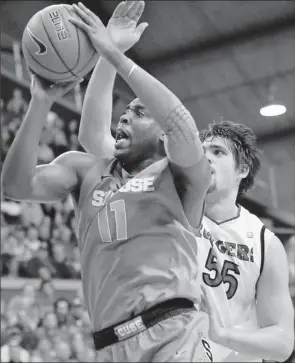  ?? By Mel Evans, AP ?? Scoop’s shot: Syracuse guard Scoop Jardine, who had17 points and seven assists, shoots in front of Rutgers’ Gilvydas Biruta during the second- ranked Orange’s 74- 64 victory Sunday in Piscataway, N. J.