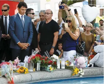  ?? PHOTO AFP ?? Le premier ministre Justin Trudeau se recueillan­t après avoir laissé des fleurs sur un mémorial de l’avenue Danforth, où a eu lieu la fusillade.