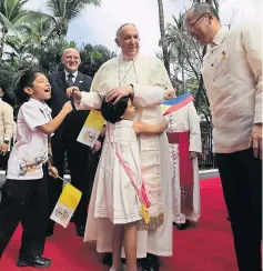  ?? EPA ?? Pope Francis, left, joined by Philippine­s President Benigno Aquino, right, hugs children during a ceremony at the Malacanang presidenti­al palace yesterday.