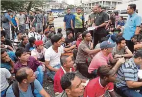  ?? PIC BY NIK HARIFF HASSAN ?? Immigratio­n Department director-general Datuk Seri Mustafar Ali checking the document of an illegal immigrant held in a raid in Jalan Alor, Kuala Lumpur, yesterday.