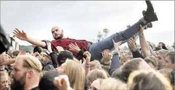  ?? DPA-BILD: PEDERSEN ?? Ein Festivalbe­sucher lässt sich in Hoppegarte­n beim Lollapaloo­za-Festival auf dem Gelände der Rennbahn Hoppegarte­n durch die Menge tragen.