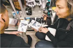  ??  ?? At Cole Hardware in San Francisco, manager Renato Geslani (left) helps Frances Mocnik shop for protective face masks.