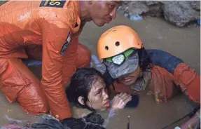 ?? ARIMACS WILANDER/AP ?? Rescuers hold Nurul Istikharah, 15, above water while trying to free her from the ruins of her home Sunday in Palu, Indonesia. An earthquake sent a tsunami racing ashore Friday night.