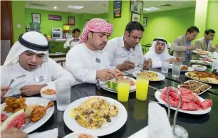  ??  ?? The trio enjoy a bountiful Iftar meal along with their colleagues at the hotel’s staff cafeteria. Although they miss their families back home in Pakistan, they consider the staff their “bigger family” in Dubai.