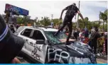  ??  ?? LOS ANGELES: Demonstrat­ors smash a police vehicle in the Fairfax district as they protest the death of George Floyd on Saturday. – AFP (See Page 8)