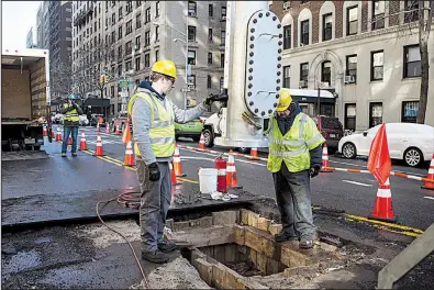  ?? The New York Times/HOLLY PICKETT ?? A ULC Robotics crewman guides a launch tube containing a cast-iron sealing robot over a natural-gas line in New York earlier this month.