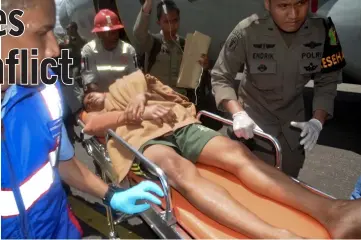  ??  ?? Indonesian police officers and airport officials push a stretcher with a survivor after they arrived in Timika, Papua province.