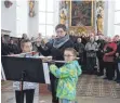  ?? FOTO: OTTO SCHÖLLHORN ?? Eine bereichern­de Einlage bot das Querflöten­trio (Tina Joos, Karina Heiß, Michaela Greif) mit Pachelbels „Canon“. Im Hintergrun­d der Männergesa­ngverein Altmannsho­fen.