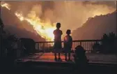  ?? Robert Gauthier Los Angeles Times ?? SIBLINGS watch from their home in Monrovia as the Bobcat fire engulfs hills on Sept. 15, 2020.