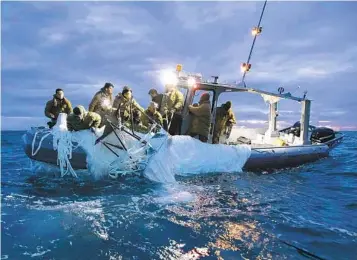  ?? U.S. NAVY VIA AP FILE ?? Sailors assigned to Explosive Ordnance Disposal Group 2 recover a surveillan­ce balloon off the coast of Myrtle Beach, S.C., on Feb. 5. The episode has raised troubling questions about the security of U.S. airspace.