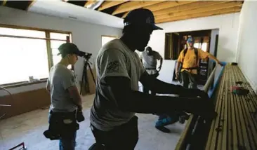  ?? GERRY BROOME/AP ?? Nearly four years after Hurricane Florence made landfall in North Carolina, volunteers from Baptists on Mission and Home Builders Institute work July 2 at Clifton Hall’s home in Spring Lake, N.C., to repair damage it caused in 2018.